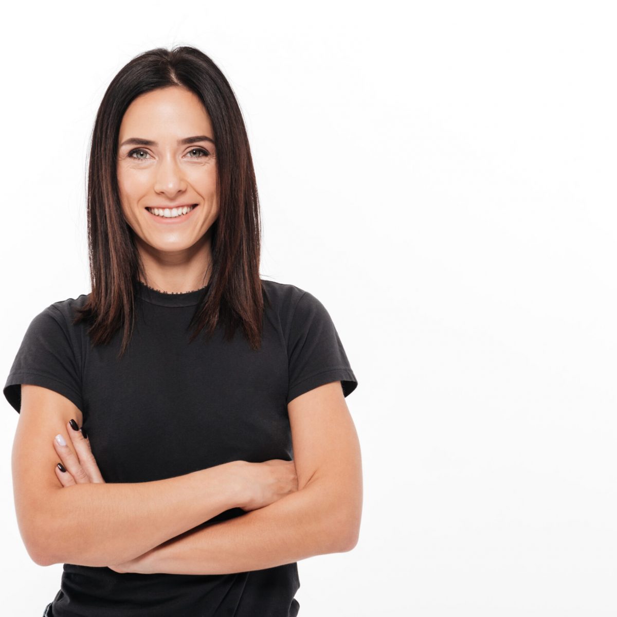 Portrait of a smiling casual woman Portrait of a smiling casual woman standing with arms folded and looking at camera with copy space isolated over white background